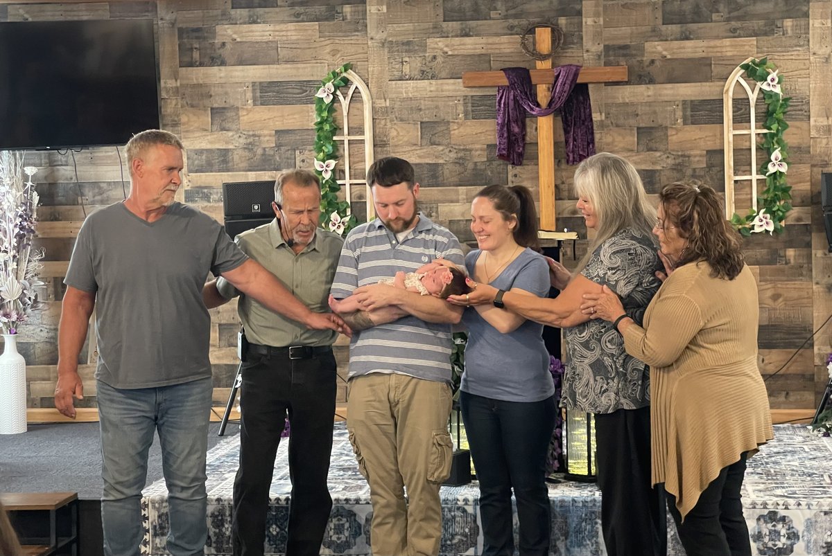 Parents holding their baby on stage during a dedication service