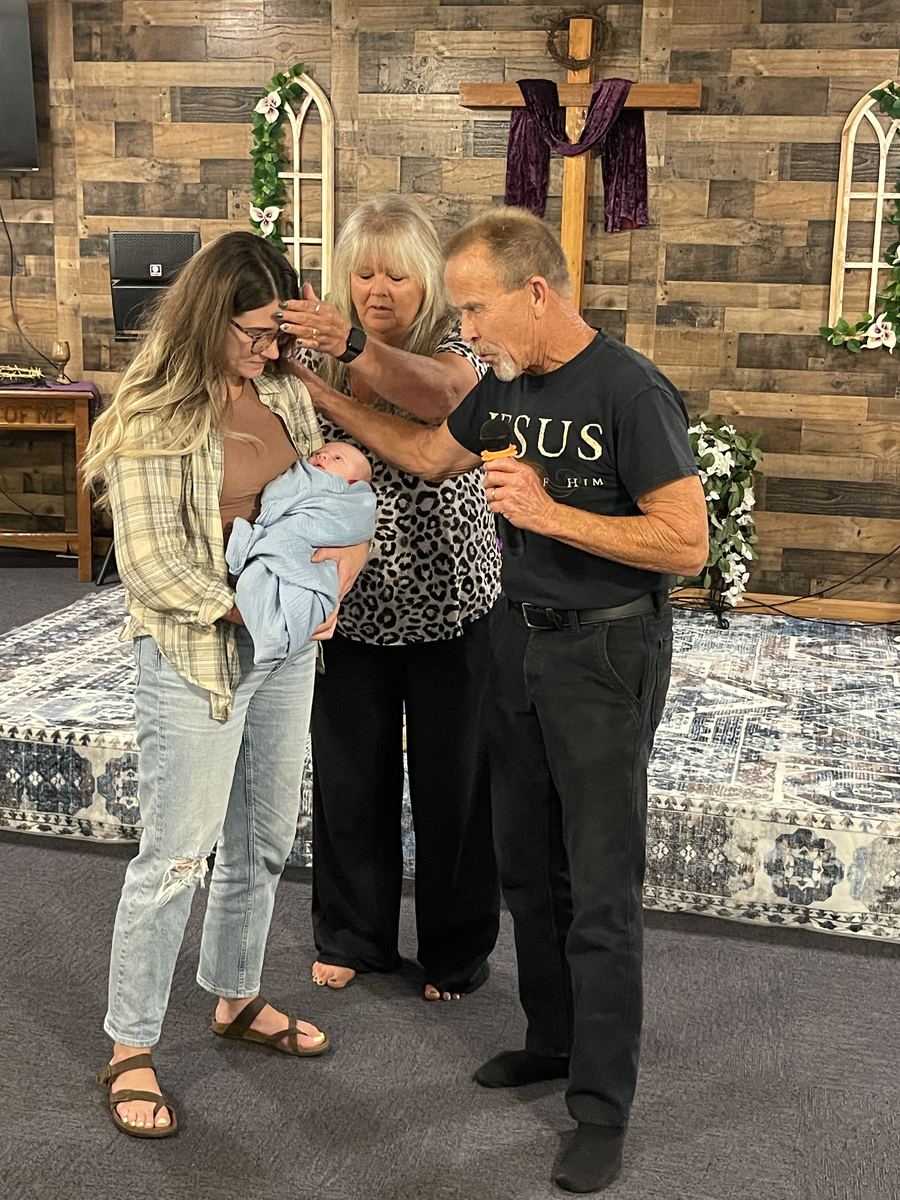 Family standing together on stage for a baby dedication