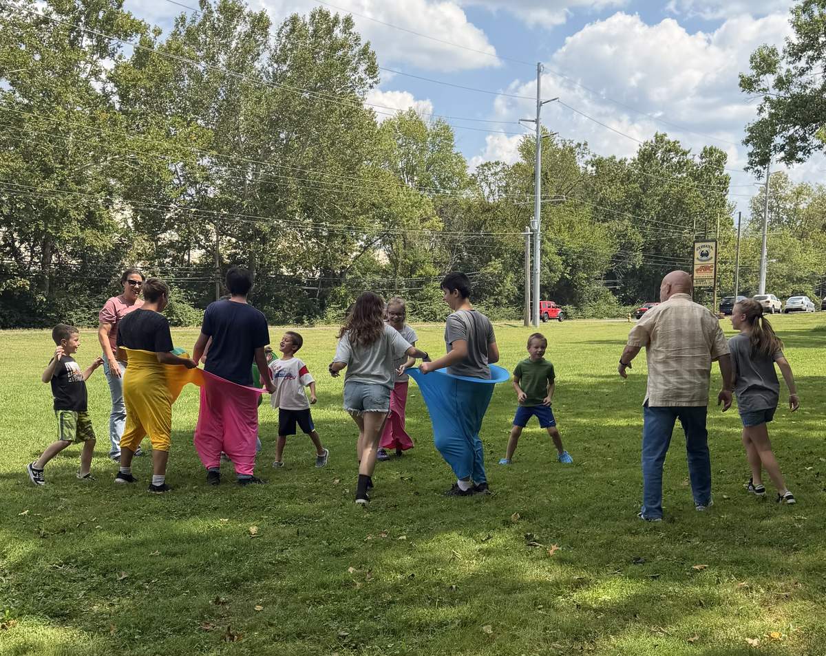 Kids ministry game with rainbow beach balls outside the church