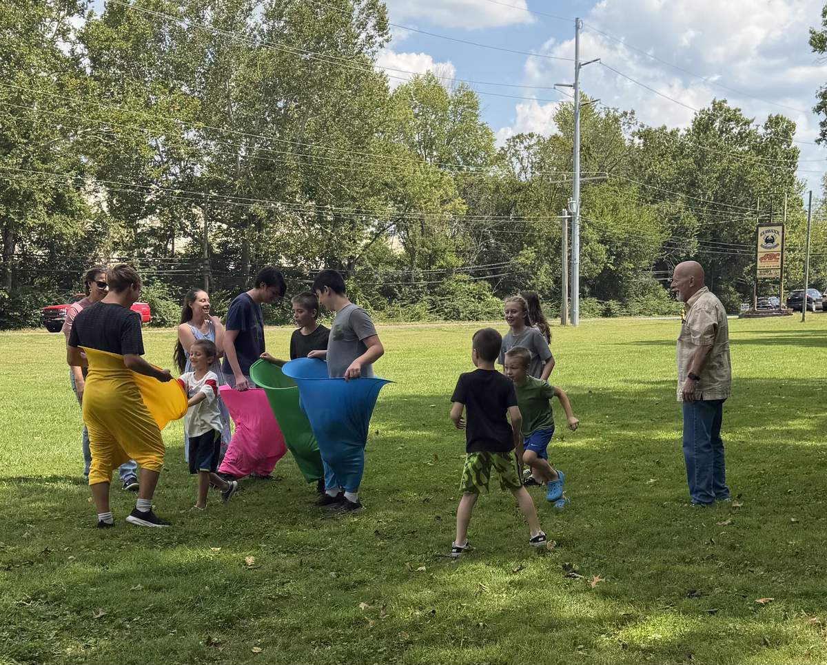 Children playing an outdoor sack-race style game near the church building