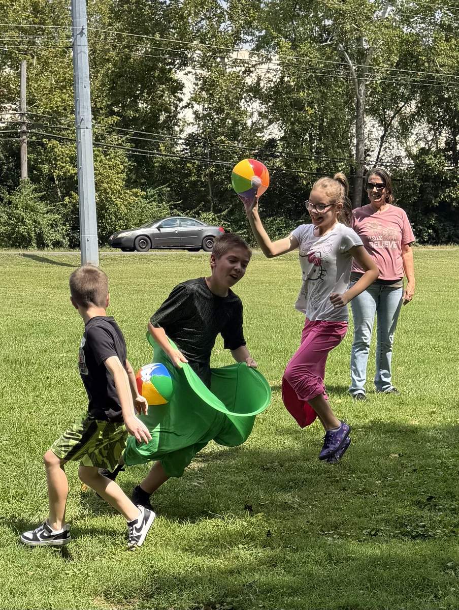 Kids ministry outdoor activity with colorful costumes and beach balls