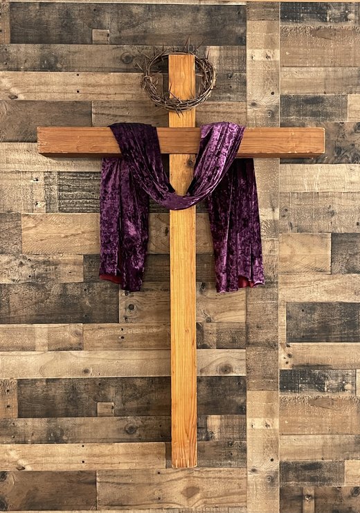 Wooden cross with a crown of thorns and a purple velvet sash, in the New Freedom Ministries sanctuary