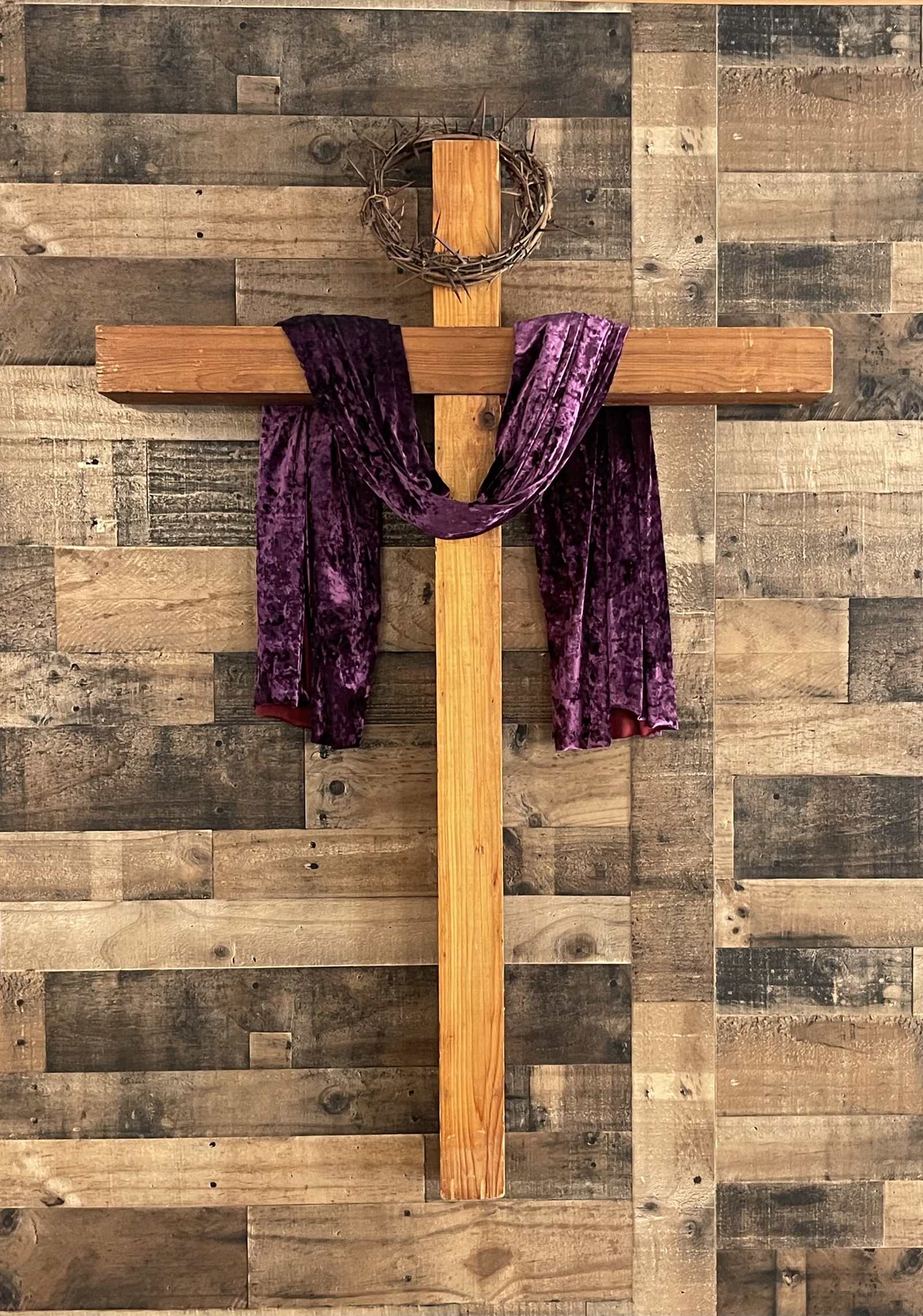Wooden cross with a crown of thorns and a purple velvet sash, in the New Freedom Ministries sanctuary